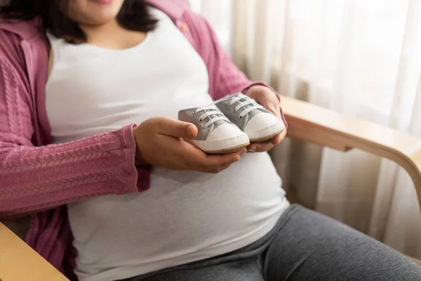 Mujer embarazada feliz y esperando un bebé en casa. — Foto de Stock