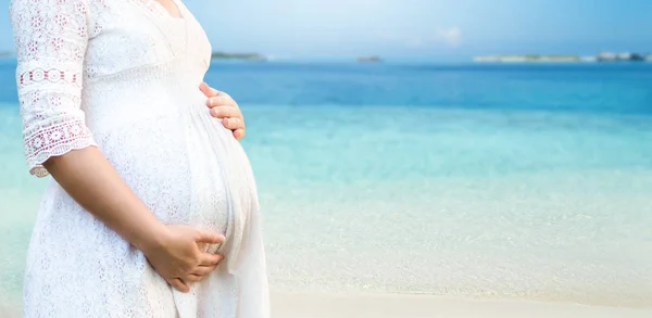Zwangere vrouw voelt zich gelukkig op het strand. — Stockfoto