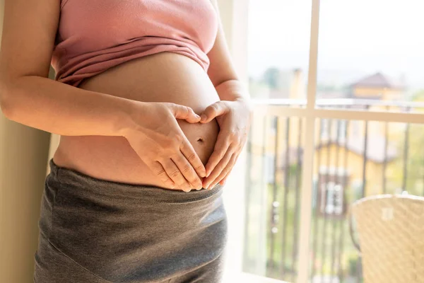 Mujer embarazada feliz y esperando un bebé en casa. — Foto de Stock