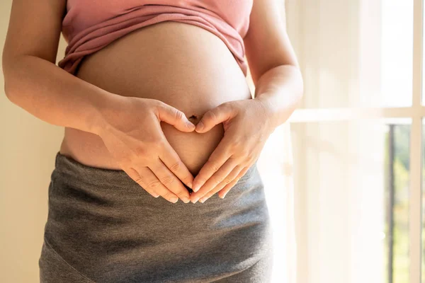 Szczęśliwa kobieta w ciąży i spodziewa się dziecka w domu. — Zdjęcie stockowe