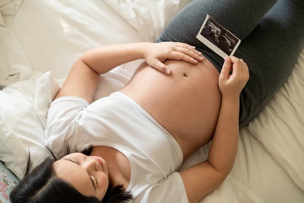 Mujer embarazada feliz y esperando un bebé en casa. — Foto de Stock