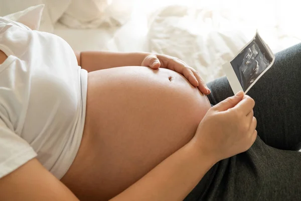 Счастливая беременная женщина и ожидающий ребенка дома. — стоковое фото