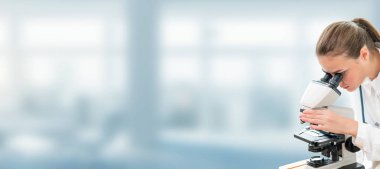 Bilim adamı araştırmacı laboratuvarda mikroskop kullanır