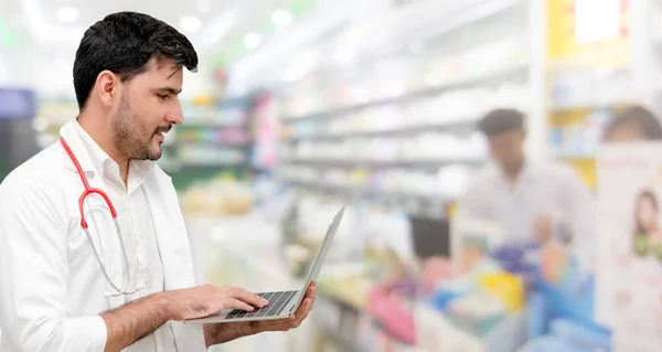 Farmacista che utilizza il computer portatile in farmacia . — Foto Stock