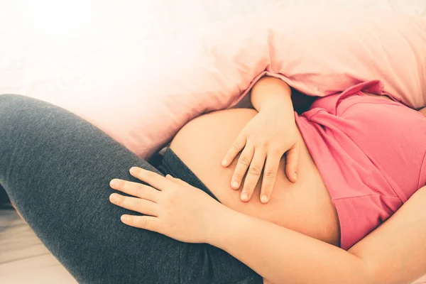 Mujer embarazada feliz durmiendo en la cama en el dormitorio. — Foto de Stock