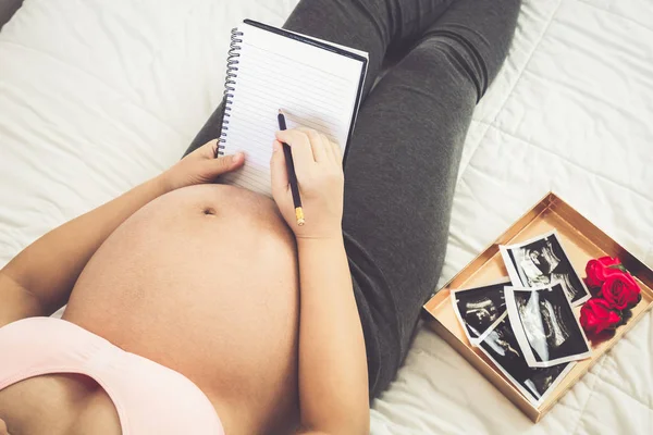 Mujer embarazada feliz y esperando un bebé en casa. — Foto de Stock