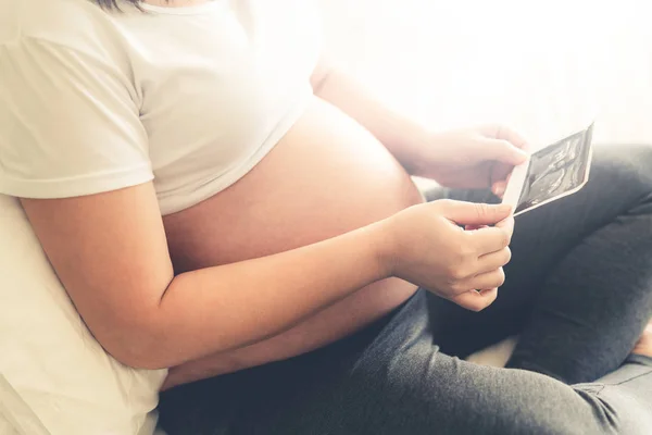 Mujer embarazada feliz y esperando un bebé en casa. — Foto de Stock