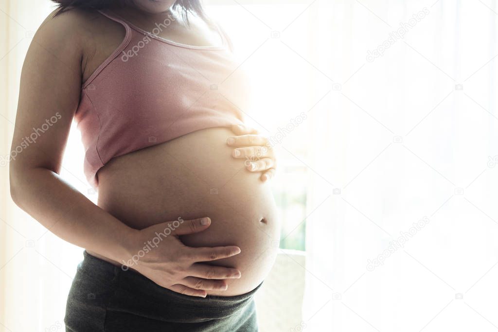 Happy pregnant woman and expecting baby at home.