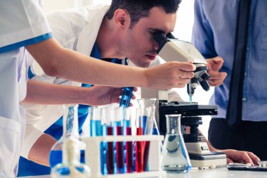 Kimya laboratuvarında çalışan bir grup bilim adamı.