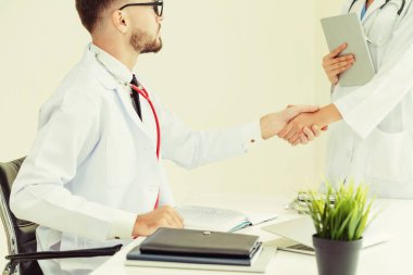 Hastanedeki doktor başka bir doktorla el sıkışıyor