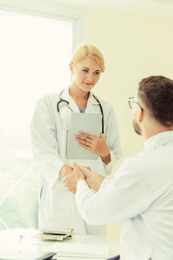 Hastanedeki doktor başka bir doktorla el sıkışıyor