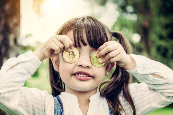 Kleines Mädchen im Besitz von digitalem Bitcoin-Geld. — Stockfoto