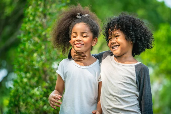 Glad liten pojke och flicka i parken. — Stockfoto