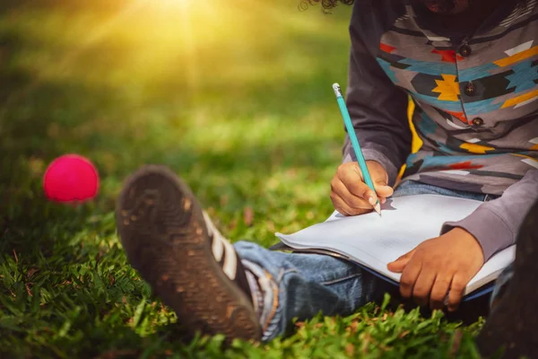 Małe dziecko pisanie na notatniku w parku. — Zdjęcie stockowe