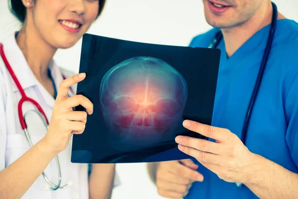 Врачи, работающие с рентгеновской пленкой головы пациента . — стоковое фото