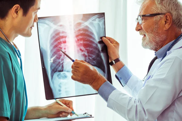 Médicos que trabajan con radiografías del tórax del paciente . — Foto de Stock