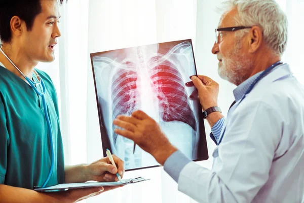 Médicos que trabalham com radiografia de tórax do paciente . — Fotografia de Stock