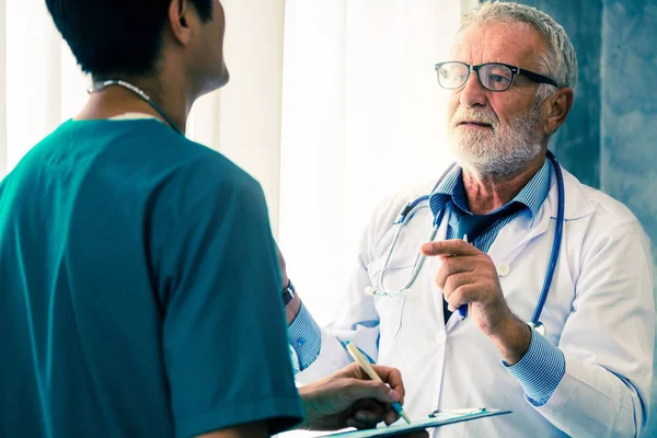 Médico senior masculino que trabaja con otro médico . — Foto de Stock