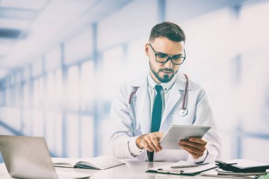 Hastanede tablet bilgisayar kullanan bir doktor..