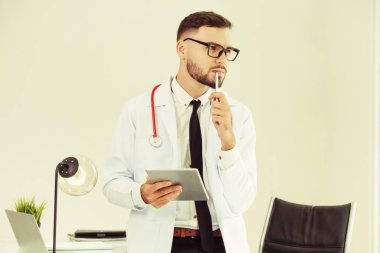 Hastanede tablet bilgisayar üzerinde çalışan doktor.