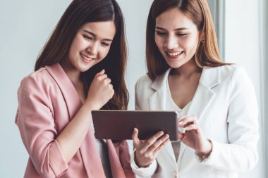 Ofiste tablet bilgisayar kullanan iş kadınları.