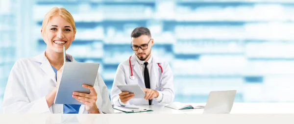 El médico en el hospital trabaja en el ordenador con el socio . — Foto de Stock