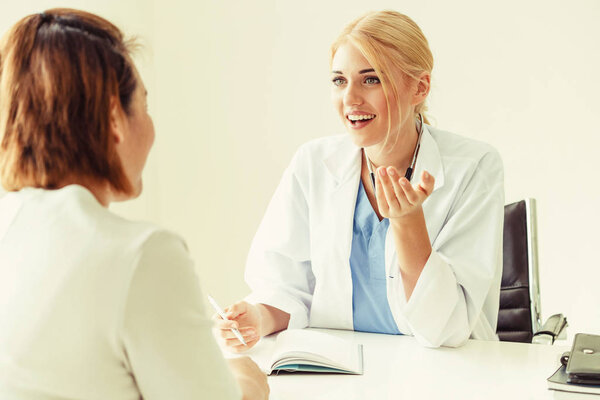 Woman Doctor and Female Patient in Hospital Office