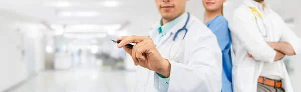 Médico que trabalha no hospital com outros médicos . — Fotografia de Stock