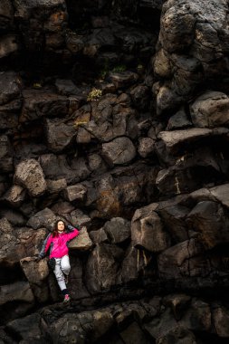 Hellnar, İzlanda kayalık sırtta kadın gezgin.