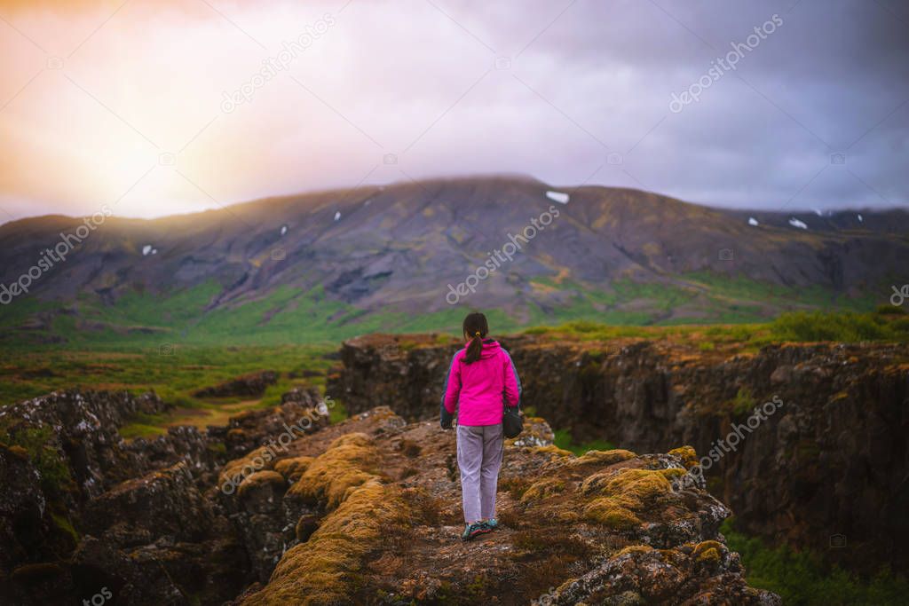 Woman traveler hiking across Iceland landscape.