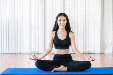 Genç kadın bir spor salonunda yoga pratik.