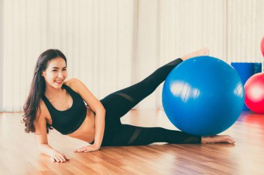 Fitness topu ile genç kadın pilates egzersizi.