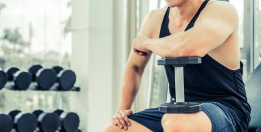 Kaslı adam vücut geliştirmeci dumbbells ile eğitim.