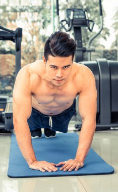 Genç adam vücut geliştirmeci fitness merkezinde itmek.