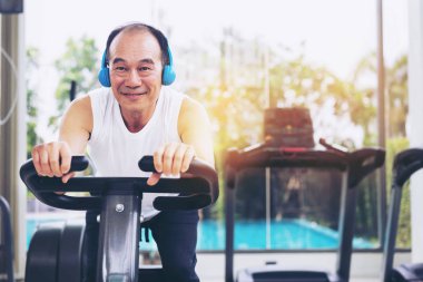 Fitness merkezinde bisiklet makinesi üzerinde Kıdemli adam egzersiz