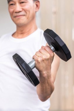 Fitness salonunda dumbbell kaldırma Kıdemli adam.