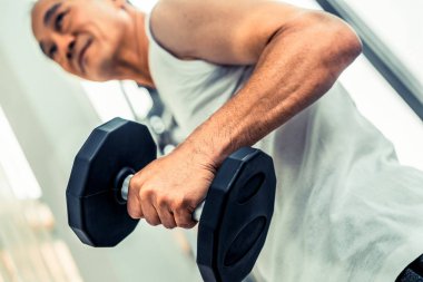 Fitness salonunda dumbbell kaldırma Kıdemli adam.
