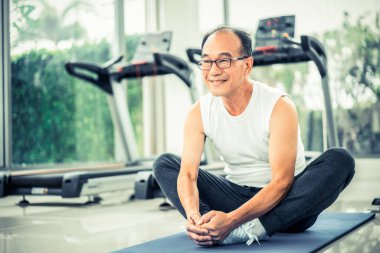 Kıdemli adam fitness merkezinde vücut germe yapmak.