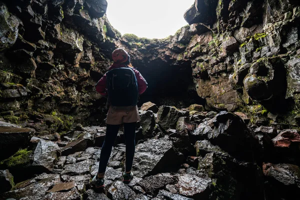 Kobieta podróżnik zbadać tunel lawy w Islandii. — Zdjęcie stockowe