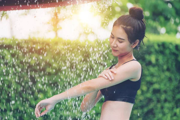 Женщина принимает душ в бассейне на курорте . — стоковое фото