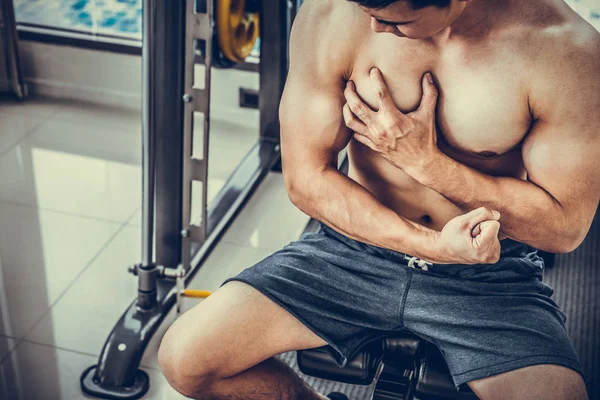 Μυώδης άνθρωπος αγγίζοντας το στήθος του στο γυμναστήριο. — Φωτογραφία Αρχείου