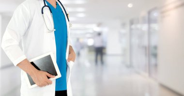 Hastanede tablet bilgisayar kullanan bir doktor..