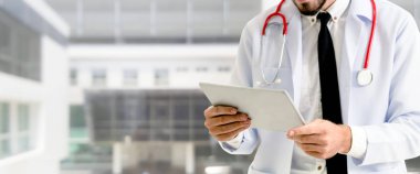 Hastanede tablet bilgisayar kullanan bir doktor..