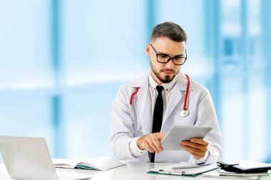 Hastanede tablet bilgisayar kullanan bir doktor..