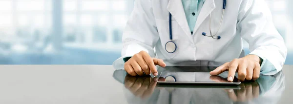 Doctor with tablet computer at hospital office.