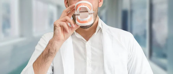 Young male dentist working in dental clinic.