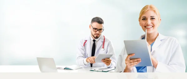 El médico en el hospital trabaja en el ordenador con el socio . — Foto de Stock