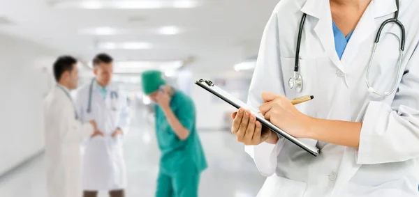 Doctor working in hospital with other doctors. — Stock Photo, Image