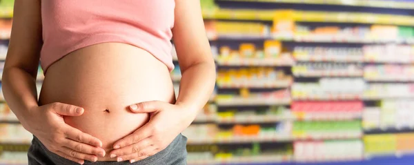 Беременная женщина в аптеке или аптеке . — стоковое фото