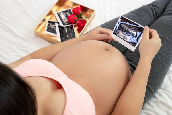 Mujer embarazada feliz y esperando un bebé en casa. — Foto de Stock